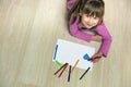 Child girl drawing with colorful pencils crayons heart on white paper. Art education, creativity concept