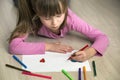 Child girl drawing with colorful pencils crayons heart on white paper. Art education, creativity concept