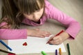 Child girl drawing with colorful pencils crayons heart on white paper. Art education, creativity concept