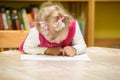 Child girl drawing with colorful pencils in preschool at the table. Little girl drawing in kindergarten Royalty Free Stock Photo