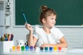 Child girl drawing with coloring pens paintind. Portrait of adorable little girl smiling happily while enjoying art and