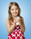 Child girl drink hold glass milk isolated on blue background. Royalty Free Stock Photo