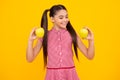 Child girl eating an apple over isolated yellow background. Tennager with fruit. Happy teenager, positive and smiling