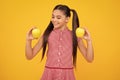 Child girl eating an apple over yellow background. Tennager with fruit. Happy teenager, positive and smiling