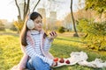 Child girl eating fresh red apples in sunny autumn park Royalty Free Stock Photo