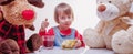 Beautiful child girl eating fruit salad with best toy friends Royalty Free Stock Photo