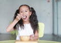 Child girl eating healthy food with deliciousness at home