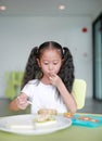 Child girl eating healthy food with deliciousness at home