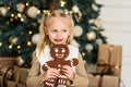 Child girl eating iced sugar cookies under Christmas tree Waiting for Christmas. Royalty Free Stock Photo