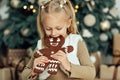 Child girl eating iced sugar cookies under Christmas tree Waiting for Christmas. Royalty Free Stock Photo