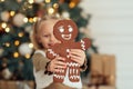 Child girl eating iced sugar cookies under Christmas tree Waiting for Christmas. Royalty Free Stock Photo