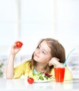 Child girl eating tomatoes fresh salad empty space background. Royalty Free Stock Photo