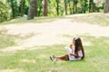 Child girl eats cotton candy on a sunny summer day and licks sticky fingers. Walk with children in the park on vacation