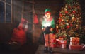 Child girl elf helper of Santa with a magic Christmas gift Royalty Free Stock Photo