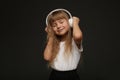 child girl enjoys music in her big white headphones and smile.Blue eyes blonde hair girl listen to music