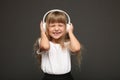 child girl enjoys music in her big white headphones and smile.Blue eyes blonde hair girl listen to music