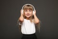 child girl enjoys music in her big white headphones and smile.Blue eyes blonde hair girl listen to music