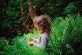 Child girl exploring nature in summer forest