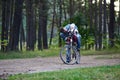 child girl and father ride a bike in the park. Cycling holidays and active weekends. Kids are sitting in a basket on a