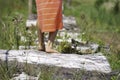 Child girl feet walking barefoot, standing on tree trunk