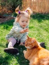 Child girl with ginger cat on lawn in spring backyard garden Royalty Free Stock Photo