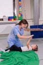 Child girl give five physiotherapist during sensory integration session Royalty Free Stock Photo