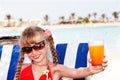 Child girl in glasses and red bikini drink juice. Royalty Free Stock Photo