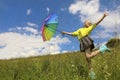 Child a girl with a great mood jumps in the summer in a field with a rainbow umbrella