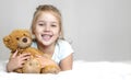 Child girl happy smiling face with teddy bear in hands. Childhood concept, empty copy space.Kid with plush toy Royalty Free Stock Photo