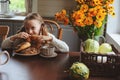 Child girl having breakfast at home in autumn morning. Real life cozy modern interior in country house Royalty Free Stock Photo