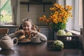 Child girl having breakfast at home in autumn morning. Real life cozy modern interior in country house Royalty Free Stock Photo