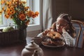 Child girl having breakfast at home in autumn morning. Real life cozy modern interior in country house Royalty Free Stock Photo