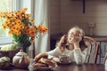 Child girl having breakfast at home in autumn morning. Real life cozy modern interior in country house Royalty Free Stock Photo