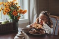 Child girl having breakfast at home in autumn morning. Real life cozy modern interior in country house Royalty Free Stock Photo