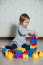 Child girl having fun and build of bright plastic construction blocks. Toddler playing on the floor. Developing toys. Early Royalty Free Stock Photo