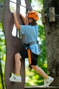 Child girl having fun at outdoor extreme adventure rope park. Active childhood, playing outdoors. Royalty Free Stock Photo