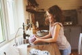 Child girl helps mother at home and wash dishes in kitchen. Casual lifestyle in real interior