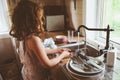 Child girl helps mother at home and wash dishes in kitchen. Casual lifestyle in real interior