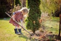 Child girl helps in spring garden with shovel Royalty Free Stock Photo