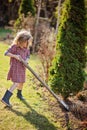 Child girl helps in spring garden with shovel Royalty Free Stock Photo