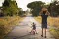 Child girl with her father carrying a pumpkin on a country road Royalty Free Stock Photo