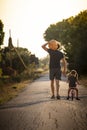 Child girl with her father carrying a pumpkin on a country road. Vertical Royalty Free Stock Photo