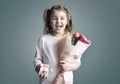 Child girl holding flowers bouquet and gift box loughing portrait. Spring promotional design card. Mother\'s da