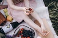 Child girl holding fruits in her hands. Close-up of arms and legs. Family picnic