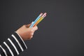 child girl holding many color pencils against gray background Royalty Free Stock Photo