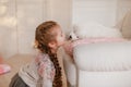 Child girl is holding puppy on her hands near pink the gift boxes Royalty Free Stock Photo