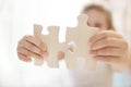 Child girl holding two big wooden puzzle pieces. Hands connecting jigsaw puzzle. Close up photo with small dof Royalty Free Stock Photo