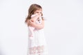 Child girl hugging her pink teddy bunny on white background. Cute girl with her toy