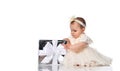 Child girl with interest unwraps a holiday gift on a white background.