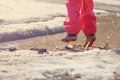 Child girl jumping in spring puddle with big splash